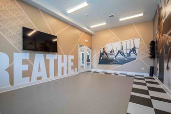 The lobby of a gym with a wall mural and a checkered floor